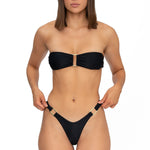 Front view of model wearing midnight black bandeau Lola bikini top and matching Brazilian cut bikini bottom by Aventura Swimwear. 