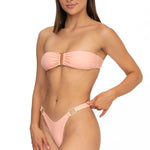 Front view of model wearing sunset peach bandeau Lola bikini top and matching Brazilian cut bikini bottom by Aventura Swimwear. 