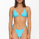 Front view of model wearing matching crystal blue Mila triangle bikini top and string bikini bottom by Aventura Swimwear. 