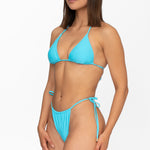 Front view of model wearing matching crystal blue Mila triangle bikini top and string bikini bottom by Aventura Swimwear. 