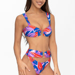 Front view of model wearing pink and purple Tropical Dusk print Seraphina bralette bikini top and matching high waist cheeky cut Seraphina bikini bottom by Aventura Swimwear. 