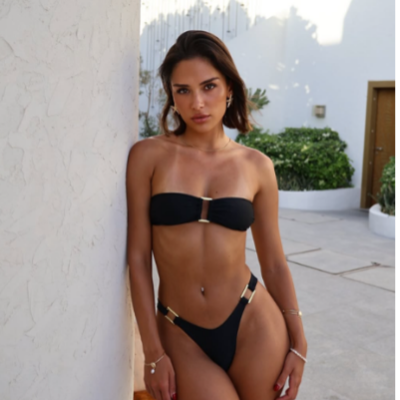 Women in black bikini leaning on a wall